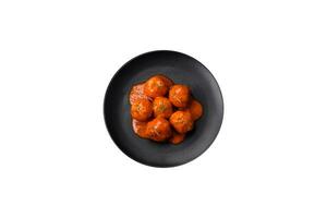 Delicious fresh meatballs in tomato sauce with salt, spices and herbs photo