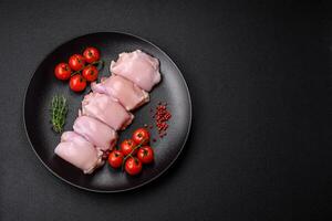 Fresh raw chicken thigh fillets with salt, spices and herbs photo