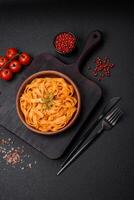 Delicious fresh pasta with pesto sauce, salt, spices and herbs on a ceramic plate photo