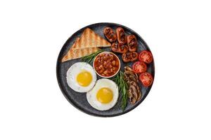 Full english breakfast with bean, fried eggs, roasted sausages, tomatoes and mushrooms photo