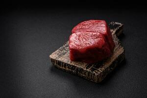 Raw fillet steak mignon beef with salt, spices and herbs photo