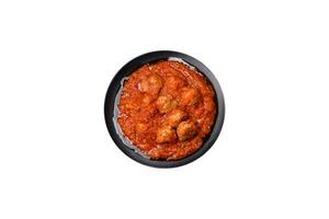 Delicious meatballs made from ground beef in a spicy tomato sauce photo