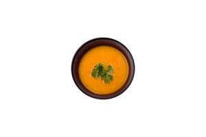 Delicious hot pumpkin and carrot soup puree with spices and herbs photo