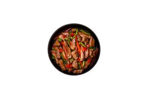 Delicious Asian teriyaki meat with red and green bell peppers photo