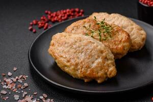 Delicious juicy cutlets or meatballs from minced chicken with salt and spices photo