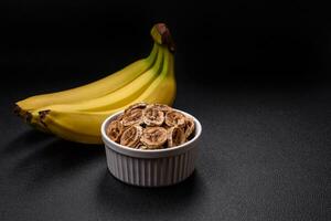 Round slices of sweet banana on a dark concrete background photo