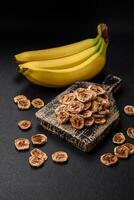 Round slices of sweet banana on a dark concrete background photo