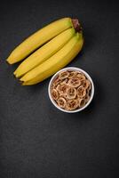 Round slices of sweet banana on a dark concrete background photo