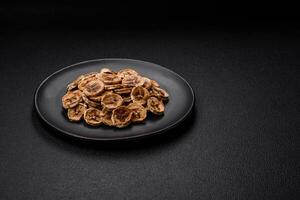 Round slices of sweet banana on a dark concrete background photo