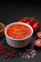 Delicious hot spicy red sauce with salt and spices in a ceramic bowl photo