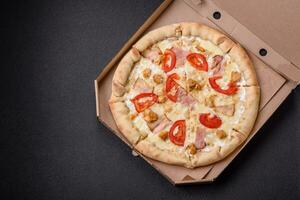 delicioso caliente Pizza con pollo, Tomates, queso y tocino, con sal y especias foto