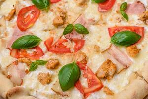 Delicious hot pizza with chicken, tomatoes, cheese and bacon, with salt and spices photo