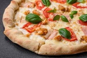 Delicious hot pizza with chicken, tomatoes, cheese and bacon, with salt and spices photo