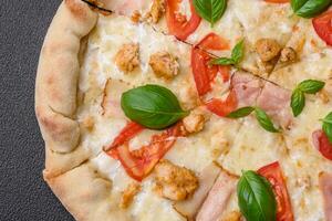 Delicious hot pizza with chicken, tomatoes, cheese and bacon, with salt and spices photo