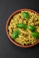 Delicious fresh pasta with green pesto sauce with basil photo