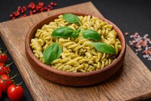 Delicious fresh pasta with green pesto sauce with basil photo