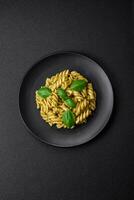 Delicious fresh pasta with green pesto sauce with basil photo