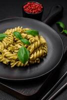 Delicious fresh pasta with green pesto sauce with basil photo