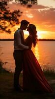 Couple sharing a kiss in front of sunset photo