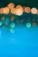 Abstract defocused yellow bokeh light on blue blurred background. Christmas, New Year, birthday. Copy space photo