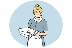 Smiling housekeeper with stack of towels photo