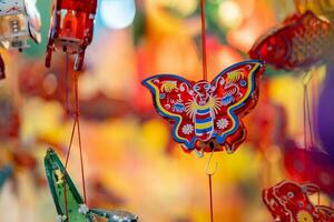 Decorated colorful lanterns hanging on a stand in the streets in Ho Chi Minh City, Vietnam during Mid Autumn Festival. Chinese language in photos mean money and happiness. Selective focus.