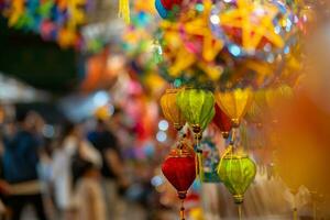 Decorated colorful lanterns hanging on a stand in the streets in Ho Chi Minh City, Vietnam during Mid Autumn Festival. Chinese language in photos mean money and happiness. Selective focus.