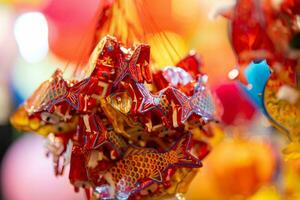 Decorated colorful lanterns hanging on a stand in the streets in Ho Chi Minh City, Vietnam during Mid Autumn Festival. Chinese language in photos mean money and happiness. Selective focus.