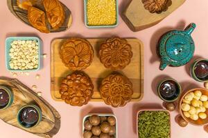 a tasty round moon cakes at mid autumn festival. Flat lay mid autumn festival food and drink on sweet pink background. photo