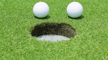 Golf balls near the hole close up photo