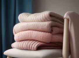 Stack of clean freshly laundered, neatly folded womens clothes on wooden table. Pile of shirts, dresses and sweaters on the table, white wall background. Created with Generative AI technology. photo