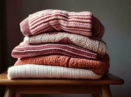 Stack of clean freshly laundered, neatly folded womens clothes on wooden table. Pile of shirts, dresses and sweaters on the table, white wall background. Created with Generative AI technology. photo