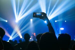 People holding smart phone and recording and photographing in concert , silhouette of hands with mobile , event background concept photo