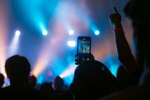 People holding smart phone and recording and photographing in concert , silhouette of hands with mobile , event background concept photo