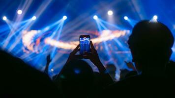 People holding smart phone and recording and photographing in concert , silhouette of hands with mobile , event background concept photo