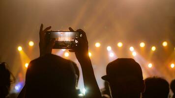 People holding smart phone and recording and photographing in concert , silhouette of hands with mobile , event background concept photo