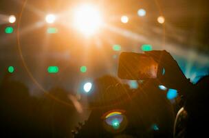 People holding smart phone and recording and photographing in concert , silhouette of hands with mobile , event background concept photo