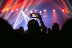 People holding smart phone and recording and photographing in concert , silhouette of hands with mobile , event background concept photo