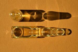 Glass ampoules on a beige orange background. photo