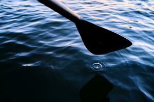 Close-up of an oar against the water. photo