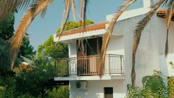 Cottage with balcony among green trees video