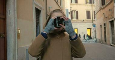 mulher usando retro vídeo Câmera dentro a rua video