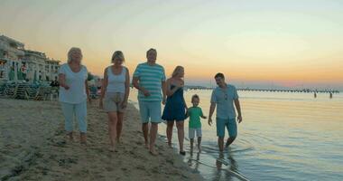 Big happy funny family walks on the beach on sea sunset background Piraeus, Greece video