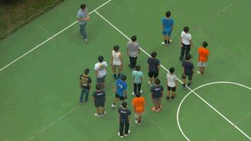 At stadium on street boys are in the line on training, then coach finished training and boys diverge video