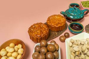 a tasty round moon cakes at mid autumn festival. Flat lay mid autumn festival food and drink on sweet pink background. photo