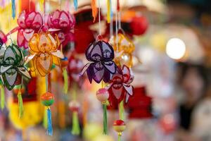 Decorated colorful lanterns hanging on a stand in the streets in Ho Chi Minh City, Vietnam during Mid Autumn Festival. Chinese language in photos mean money and happiness. Selective focus.