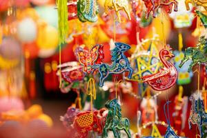 Decorated colorful lanterns hanging on a stand in the streets in Ho Chi Minh City, Vietnam during Mid Autumn Festival. Chinese language in photos mean money and happiness