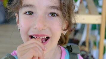 The child shakes the front baby tooth and smiles a toothless smile close-up. Changing teeth to molars in childhood video