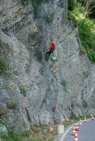 Climber placing safety nets to avoid falling rocks photo