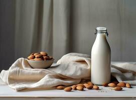 Organic almond milk in glass bottle near ceramic bowl with raw almonds on stone table in the kitchen ready for cooking. Created with Generative AI technology. photo